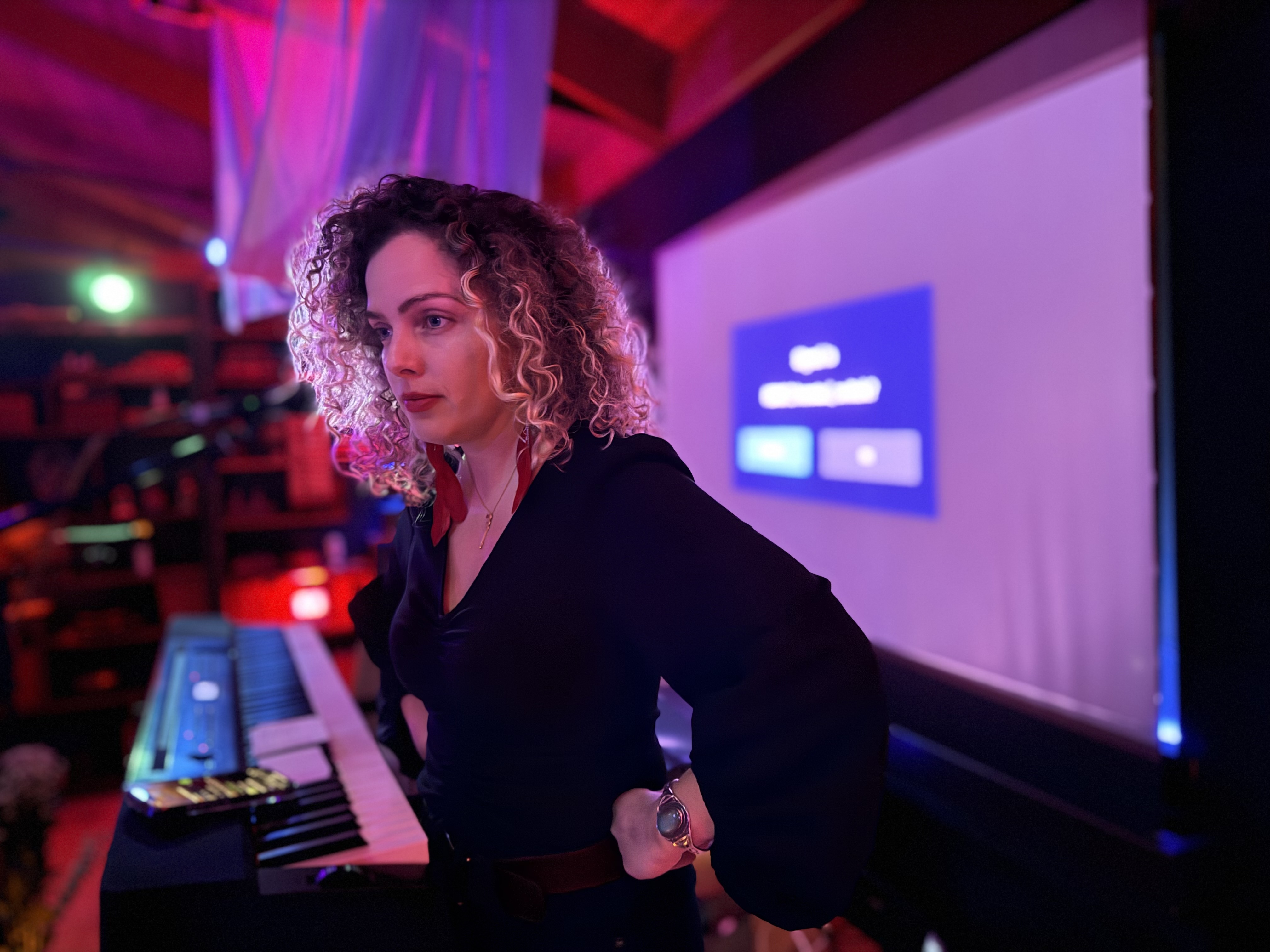 Lauren onstage at a keyboard, projection screen behind her